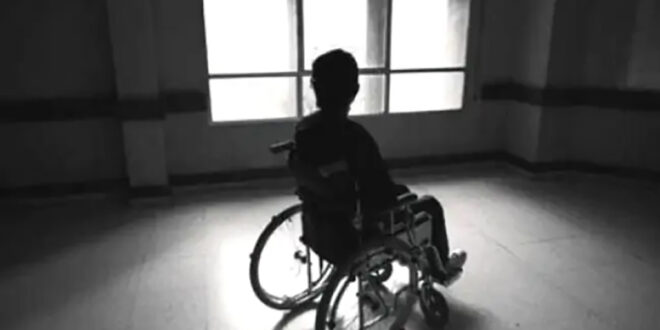 Hombre en silla de ruedas pegado a un ventanal